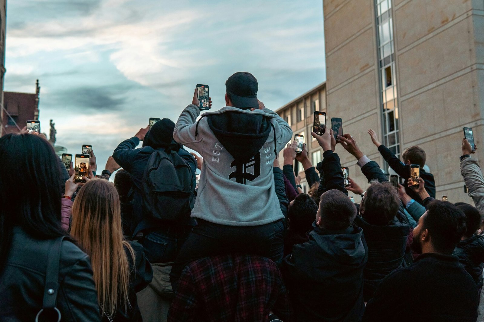 a group of people taking pictures with their cell phones